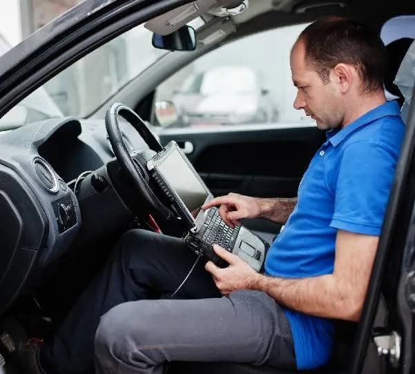 Monteur programmeert autosleutel via OBD diagnostiek in de auto op locatie